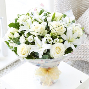 features white lilies, lisianthus and roses. Classically beautiful!