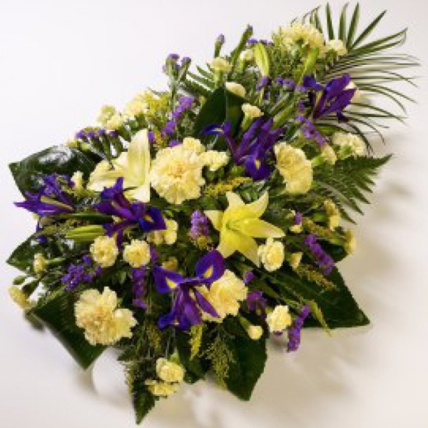 Lilies and Carnations are presented with Irises, Spray Carnations and luxury foliage to create this lemon and blue teardrop spray.