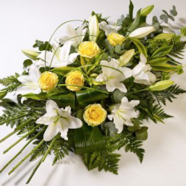 Beautiful yellow roses presented with white oriental lilies.